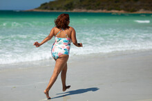 Lady Running Along Sea Shore Wearing Swimming Costume