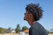 © Austockphoto - profile of young man with frizzy hair against blue sky