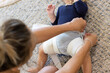© Austockphoto - mother applying hip abduction brace to baby with hip dysplasia