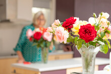 Roses In Vase With Lady In Background Behind