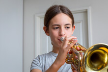 Young Girl Practising Her Trumpet At Home
