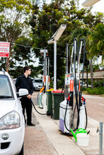 Young Man Filling Car Up With Petrol At Country Service Station In Australian Town