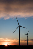 Fototapeta  - Wind farm in agricultural landscape, sunset wind turbines producing electricity, wind energy is renewable energy, clean, renewable energy source, wind turbines against the setting sun