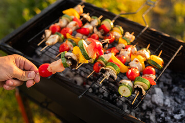 Wall Mural - Crop man showing chicken and vegetable skewer