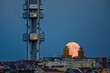 The rising full moon above Prague cityscape with Zizkov TV tower.