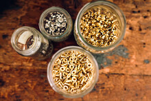 Directly Above Shot Of Jars Filled With Construction Nuts On Table At Workshop