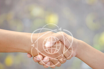 Handshake cloaseup on blur background for deal in business concept with globe icon