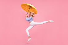 Full Length Photo Of Dreamy Sweet Girl Dressed Blue Top Jumping High Holding Umbrella Isolated Pink Color Background