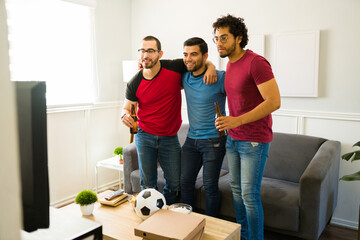 Young men hugging and celebrating watching the football game