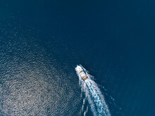 Aerial Top View Of A Motor Yacht Cruising Over Blue Sea