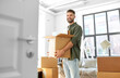 canvas print picture - moving, people and real estate concept - happy smiling man holding box with stuff at new home