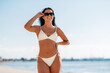 © Syda Productions - people, summer and swimwear concept - happy smiling young woman in bikini swimsuit on beach