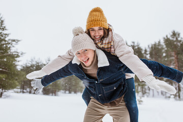 Canvas Print - people, season, love and leisure concept - happy couple having fun in winter park