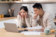 © Prostock-studio - Shocked asian husband and wife checking their expenses