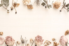 Decoration Of Roses And Other Dried Flowers On A Light Woodgrain Background	