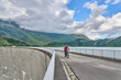 nice senior woman riding her electric mountain bike on the dam of Kpssee fresh water reservoir in the silvrettea mountain range, Tirol, Austria