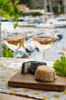 Rose wine in glasses served with goat cheeses on outdoor terrace with view on old fisherman's harbour with colourful boats in Cassis, Provence, France