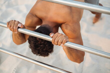 Anonymous Hispanic Ethnic Sportsman Exercising On Bar On Sandy Beach