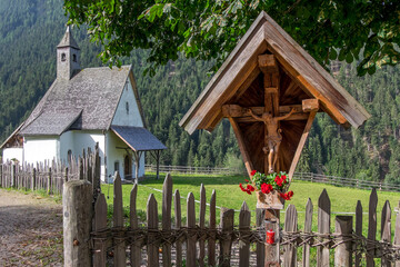 cruz de caminos y capilla en el pueblo de nova levante en sudtirol, italia
