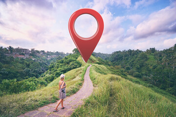 Tourism and travel. Young woman walking on path in Ubud, Bali. 3d red location pin GPS pointer on the background.