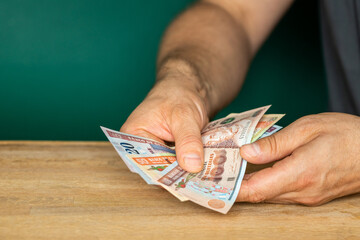 Guatemala money, a man in a shirt holds banknotes in his hands, counting money, financial settlements, Creative business concept