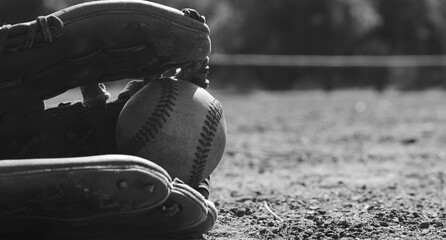 Canvas Print - Sports game concept shows baseball glove with ball on field during summer in black and white.