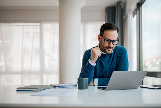 serious businessman working on laptop. male professional is planning strategy while sitting at offic