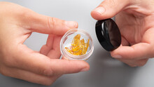 Golden Cannabis Wax In Female Hands In A Box, Strong Thc Extract.