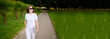 © GRON777 - Full length portrait of a woman in sunglasses and summer clothes walking in the park with a laptop outside. Banner