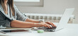 © Tijana - Close up photo of woman hands typing business report on a laptop keyboard at the kitchen desk with a digital tablet, notebook and bluetooth earphones