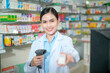 © tonefotografia - Female pharmacist scanning barcode on a medicine box in a modern pharmacy drugstore.