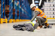 A warehouse worker having an accident and manager giving him first aid.