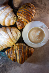 chocolate croissant and a cup of coffee on a blackboard top view