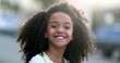 © Marco - Mixed race child smiling at camera. Happy African Little girl portrait face close-up