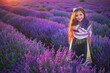 Girl with flowers in traditional folklore bulgarian dress in lavender field