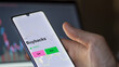 © maurice norbert - An investor's analizing the buybacks etf fund on a screen. A phone shows the prices of Buybacks