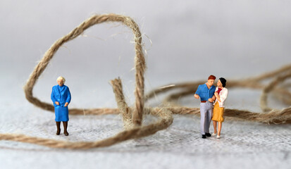 Miniature people standing with rope. The concept of conflict between mother-in-law and daughter-in-law.
