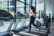 © PBXStudio - Asian woman running on a treadmill near a large window in the gym.Healthy lifestyle concept.