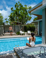 Wall Mural - couple men and women on a luxury vacation at a pool villa. men and woman by swimming pool in the sun