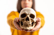 caucasan medical student holding an artificial molder of a human skull - isolated closeup. High quality photo