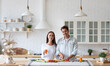 © BestForYou - Happy couple is preparing healthy food on light kitchen. Cooking together salad