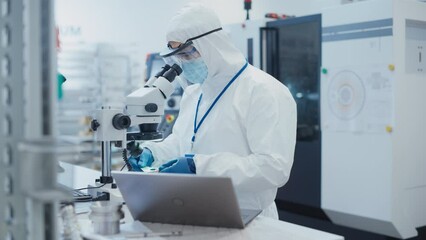 Leinwandbilder - Modern Technology Concept: Engineer in Coverall Working on Laptop Computer, Examining a Circuit Board with Microchips Through a Microscope. Technician Testing New Electrical Equipment.
