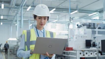 Fototapete - Portrait of a Happy and Smiling Asian Female Engineer in White Hard Hat Standing with Laptop Computer at Electronic Manufacturing Factory. Successful Employee Posing for Camera.