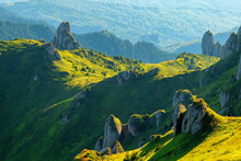 Landscape Scene From The Ciucas Mountains In Romania With Green Rolling Hills And Cliffs