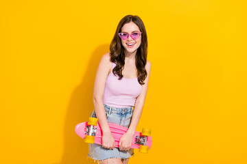 Poster - Portrait of cheerful person hold skate toothy smile enjoy weekend vacation isolated on yellow color background