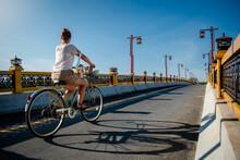 Mujer Cruzando Un Puente En Su Bicicleta Al Atardecer De Un Día Soleado