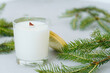 Soy candles in transparent glass jar with wooden lid. Candle on light background close-up.