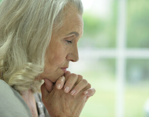 Sticker - Close up portrait of sad  senior woman praying