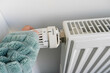 canvas print picture - Person mit decke schaltet Thermostat auf Heizung herunter, um Energie zu sparen.
