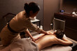 © Dragosh - Rear view of a young woman having a back massage treatment. Spa and healthy concept.